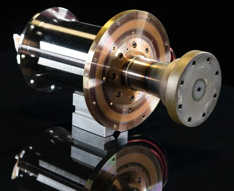 A cylindrical metal Stirling convertor with a flanged housing and polished surfaces, photographed against a plain background.